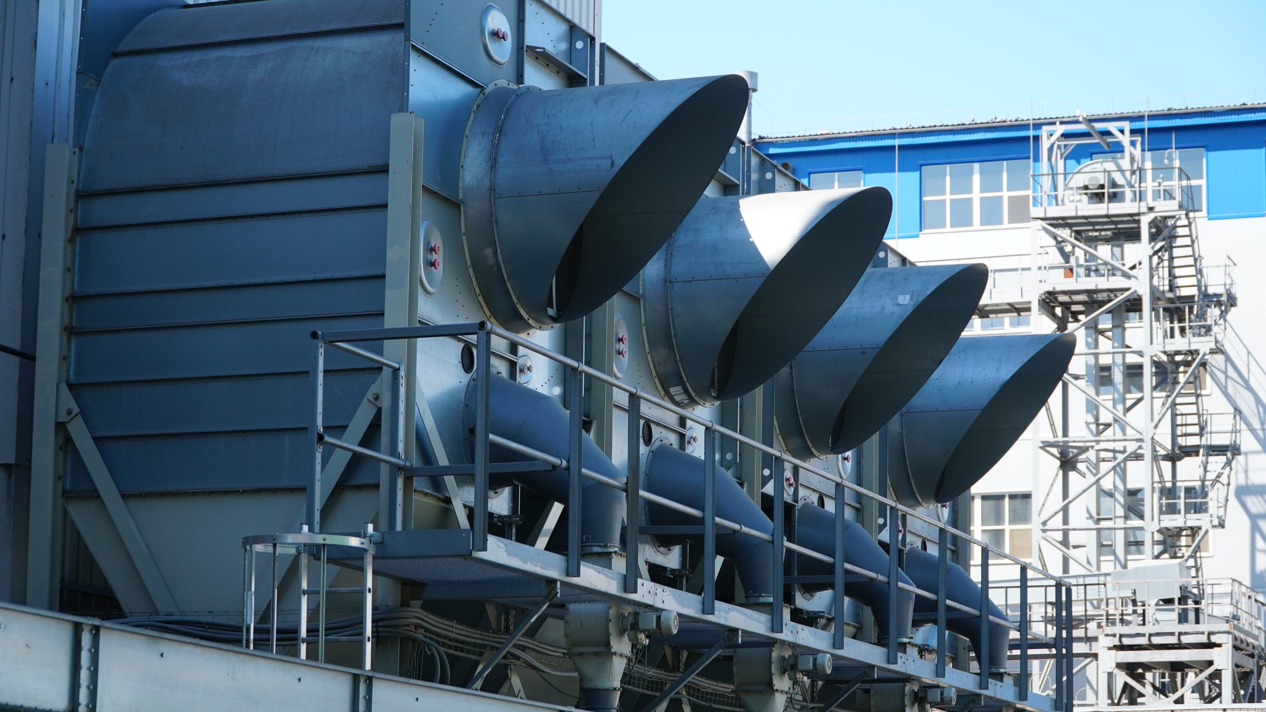 industrial air conditioner. Air conditioner units HVAC on a roof of industrial building with blue sky and clouds in the background.
